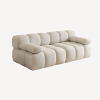 Canapé droit 2 places en chenille beige clair, vue de profil, coussins arrondis.