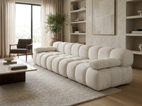 Canapé 3 places droit en chenille blanc, forme longue avec coussins compressés.