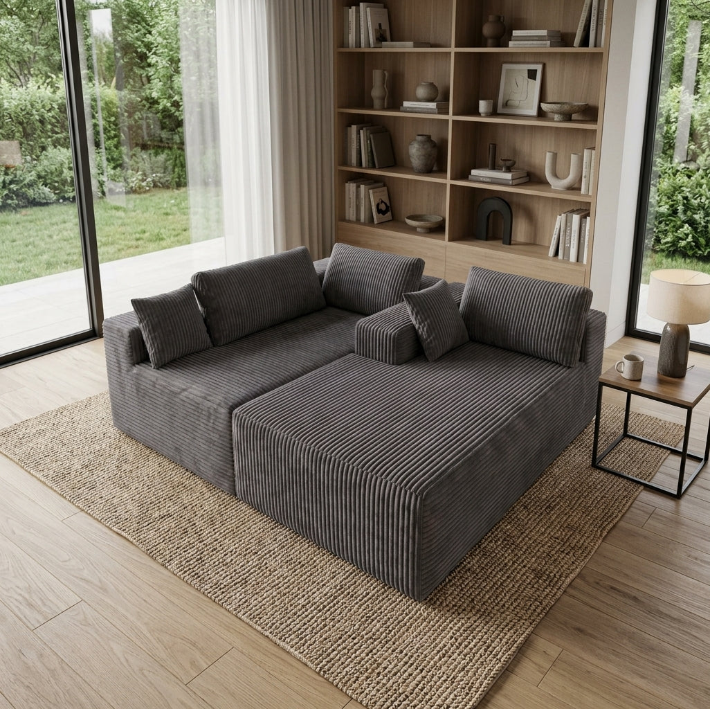 Canapé d’angle gris en velours côtelé, coussins carrés, assise et méridienne.