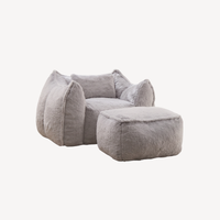 Fauteuil 1 place en fourrure gris clair, repose-pied, vue latérale