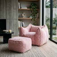 Fauteuil en fourrure rose avec repose-pied assorti, accoudoirs et dossier arrondis.