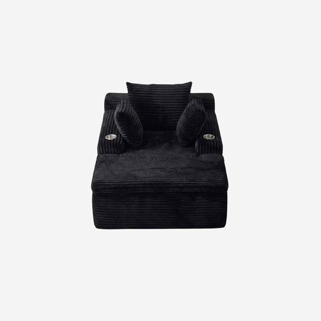 Fauteuil compressé 1 place en velours côtelé noir, face avant avec coussins roulés.