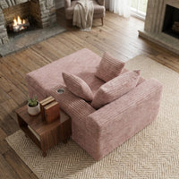 Fauteuil compressé 1 place en velours côtelé rose, assise longue et coussins de dossier.